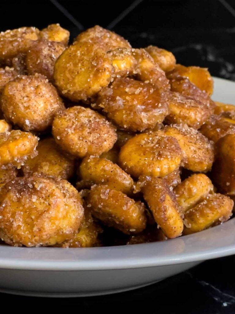 Churro snack mix piled high in a white bowl.