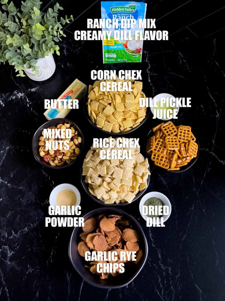Dill pickle Chex mix ingredients on a dark surface.