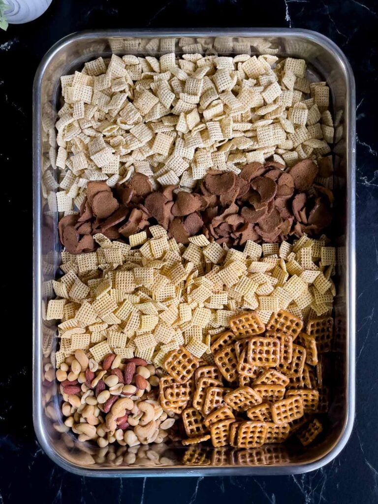 Cereal ingredients for Dill Pickle Chex Mix in a large baking pan.