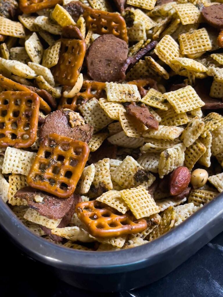 Baked Dill Pickle Chex mix combined with seasonings in a large baking pan.