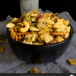 Dill Pickle Chex Mix in a dark bowl on a light linen napkin.
