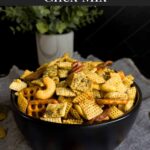 Dill Pickle Chex Mix in a dark bowl on a light linen napkin.