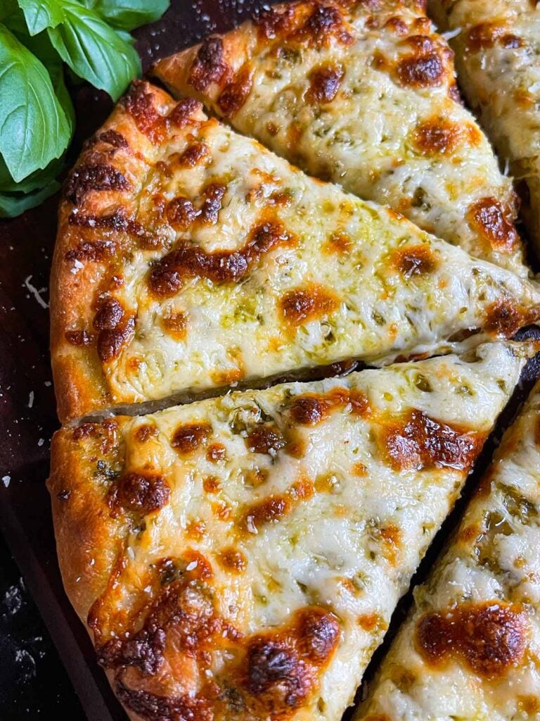 Homemade pesto and cheese pizza using homemade pizza dough.