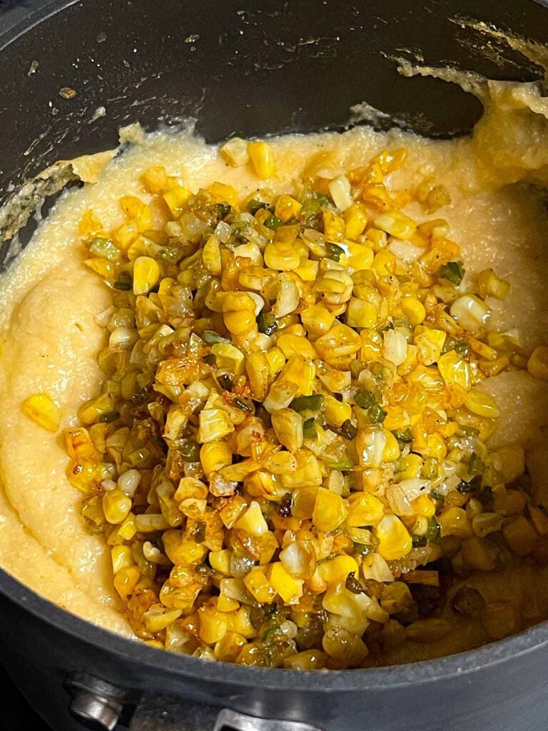 Adding a butter corn mixture to polenta.