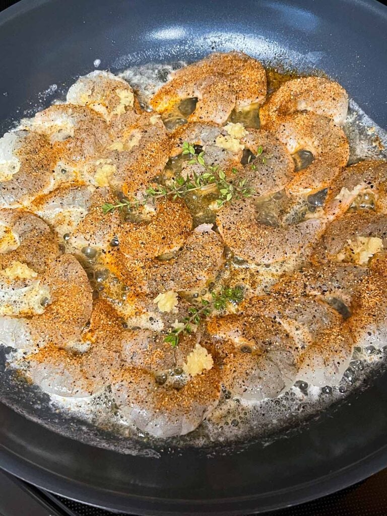 Shrimp cooking in a skillet.