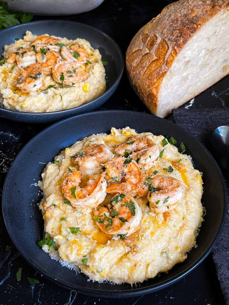 Spicy shrimp on a bed of Cajun polenta in a dark bowl.