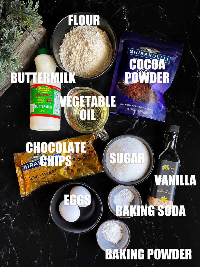 Ingredients needed to make double chocolate muffins on a dark surface.