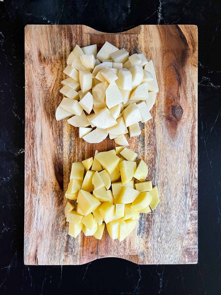 Potatoes cubed on a cutting board.