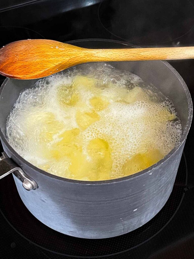 Potatoes boiling in a saucepan.