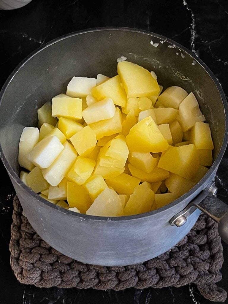 Cooked potatoes in a saucepan.