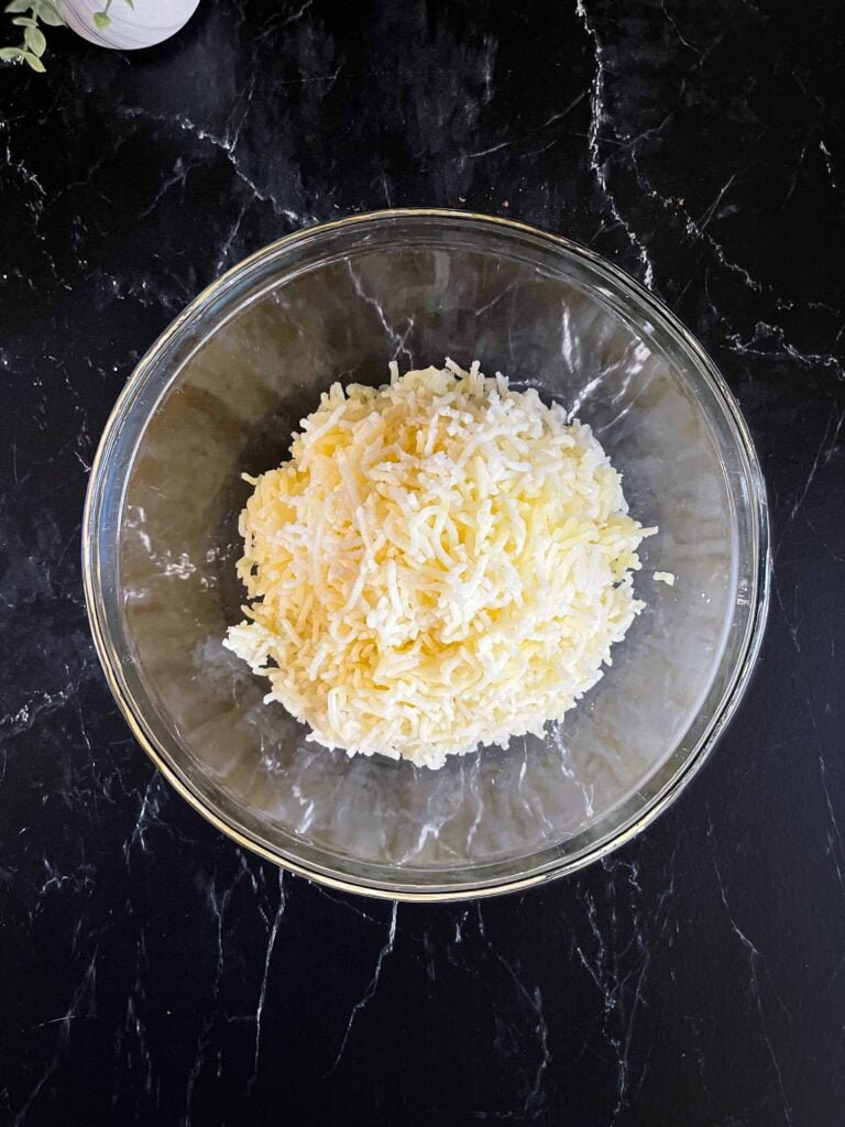 Potatoes that have been passed through a ricer in a glass bowl.