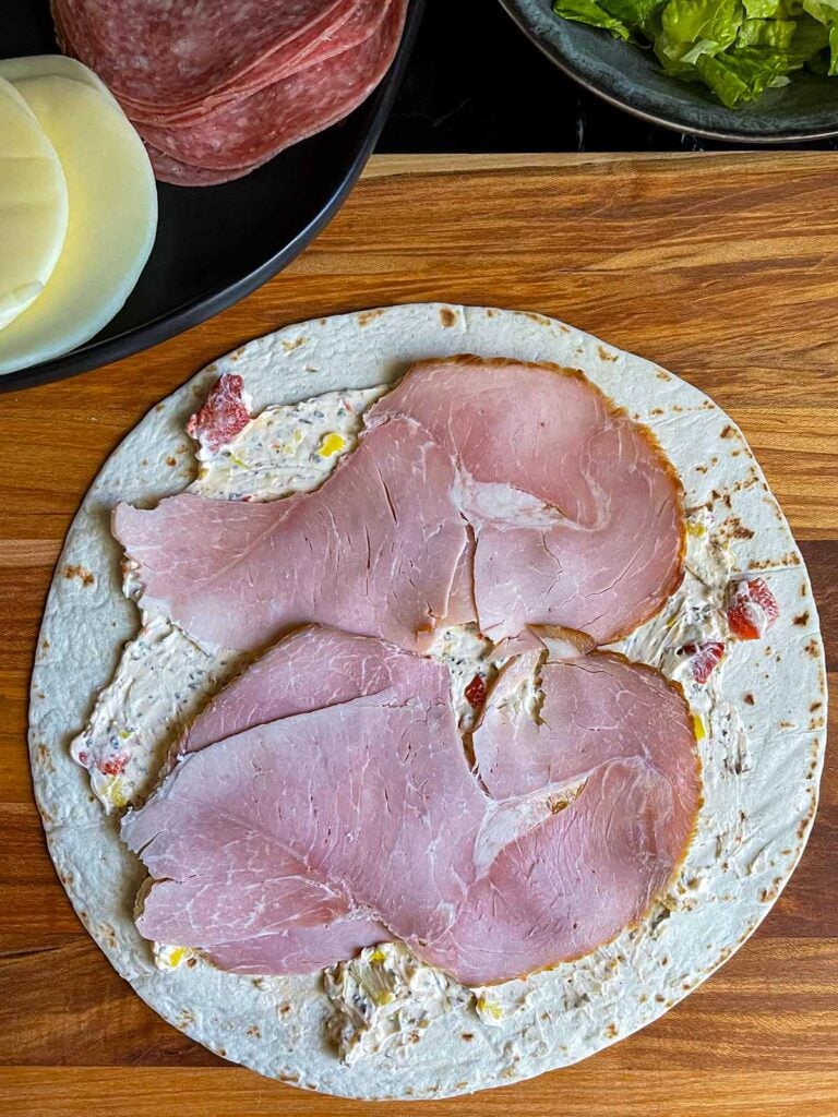 A layer of ham on the italian pinwheel as it's being made.