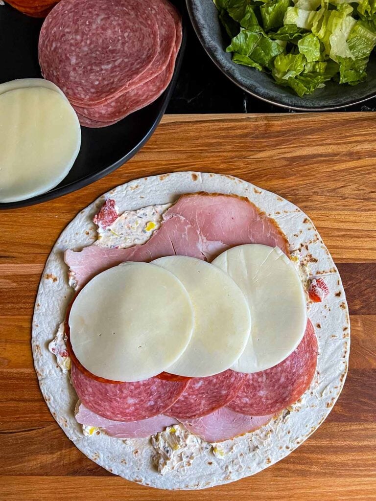 A layer of provolone cheese on the italian pinwheel as it's being made.