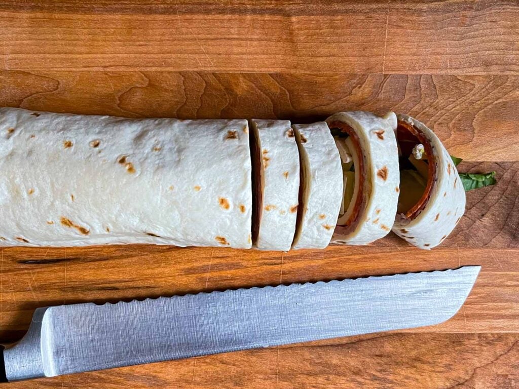 Slicing the italian wrap into pinwheels.