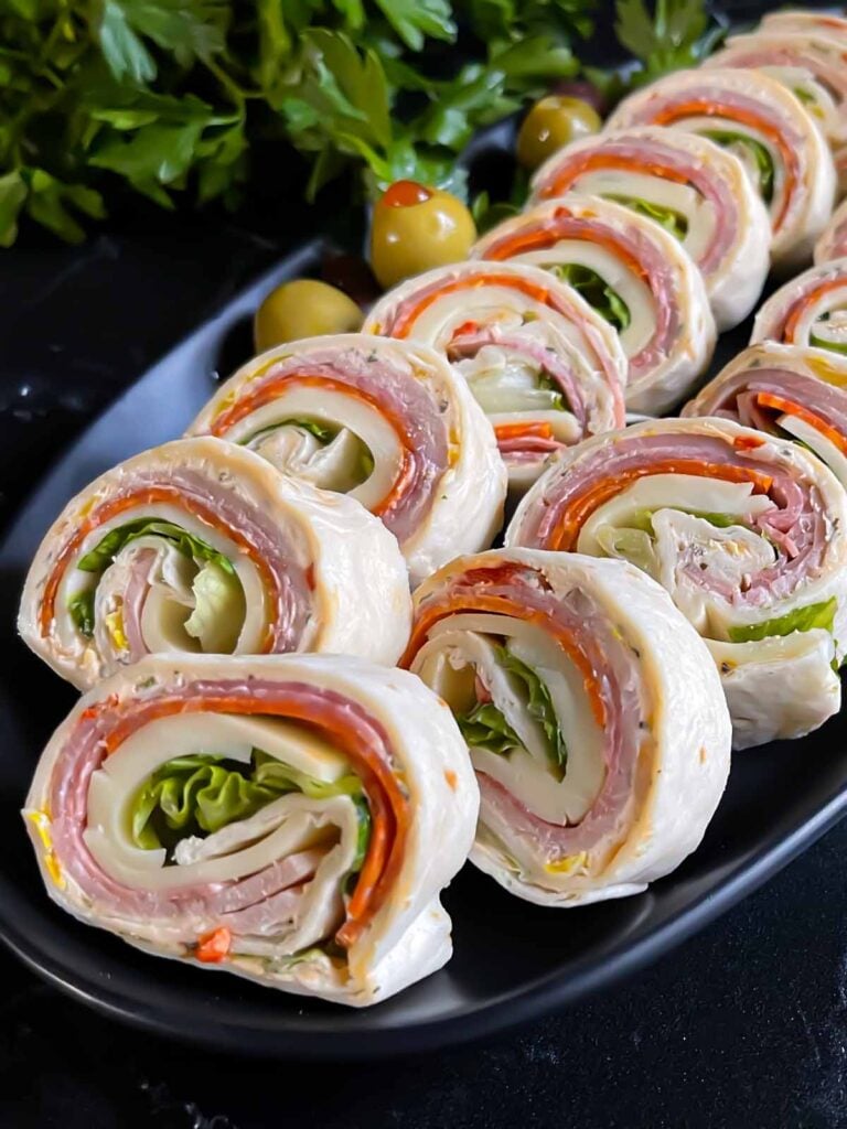 Italian pinwheels on a dark plate on a dark surface.