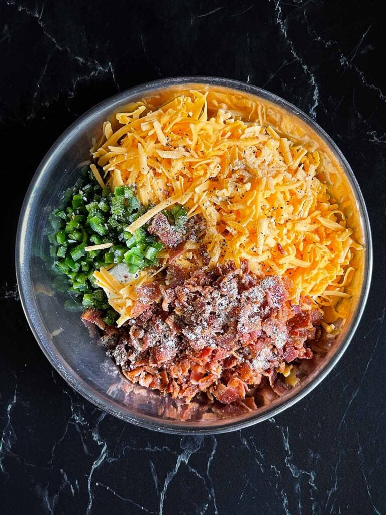 Jalapeno popper pinwheel ingredients together in a metal mixing bowl.