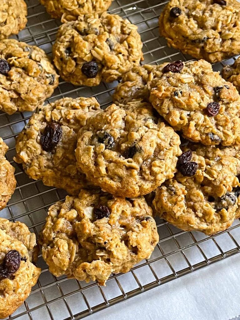 Baked old fashioned oatmeal raisin cookies on a wire cooling rack.