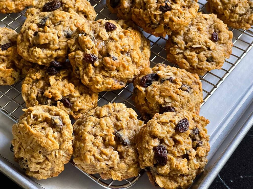 Baked old fashioned oatmeal raisin cookies on a wire cooling rack.