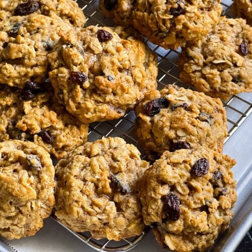 Baked old fashioned oatmeal raisin cookies on a wire cooling rack.