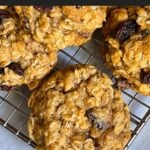 Baked old fashioned oatmeal raisin cookies on a wire cooling rack.