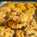 Baked old fashioned oatmeal raisin cookies on a wire cooling rack.