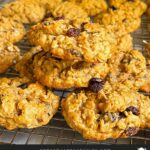 Baked old fashioned oatmeal raisin cookies on a wire cooling rack.