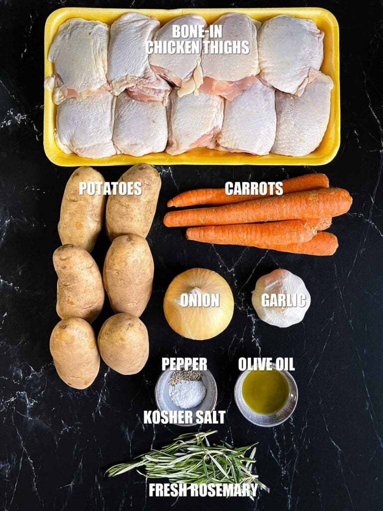 Ingredients for one pan roasted chicken and vegetables on a dark surface.