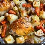 One pan roasted chicken and vegetables in a foil and parchment paper lined baking sheet.