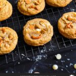 Salted Butterscotch Pretzel Cookies on a cooling rack on a dark surface.