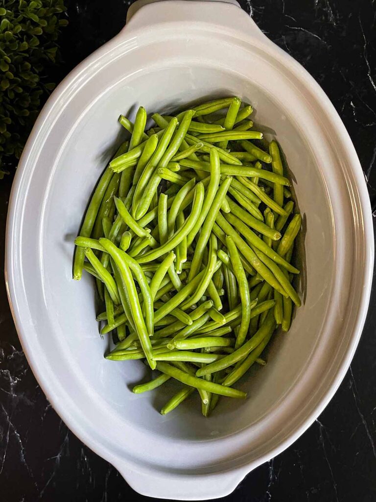 Raw green beans in a slow cooker.