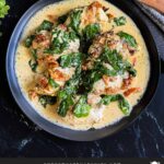 Slow Cooker Tuscan Chicken in a dark bowl on a dark surface.