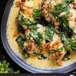 Slow Cooker Tuscan Chicken in a dark bowl on a dark surface.