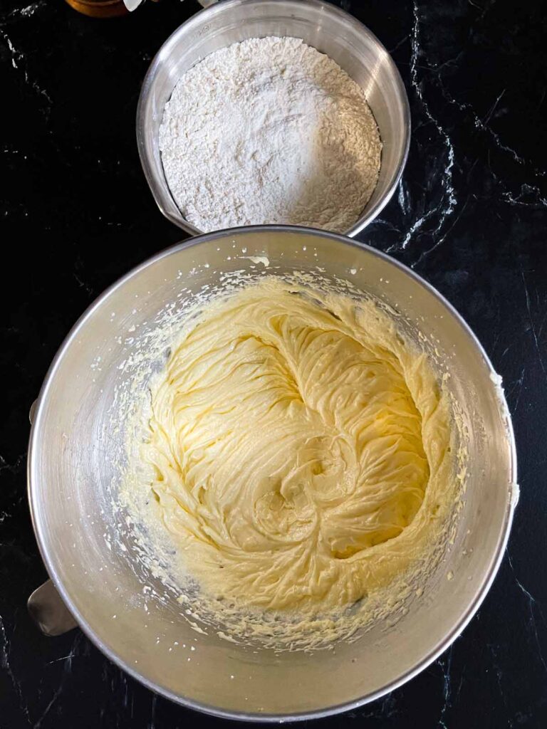 Cream butter and sugar for old fashioned sour cream pound cake in a metal mixing bowl with the dry ingredients in another metal bowl.