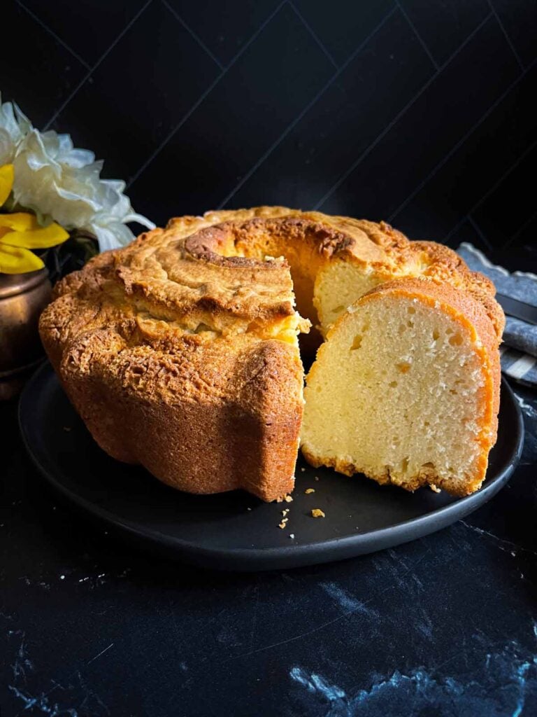 Old fashioned sour cream pound cake on a dark plate.