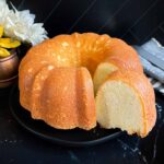 Old fashioned sour cream pound cake on a dark plate.