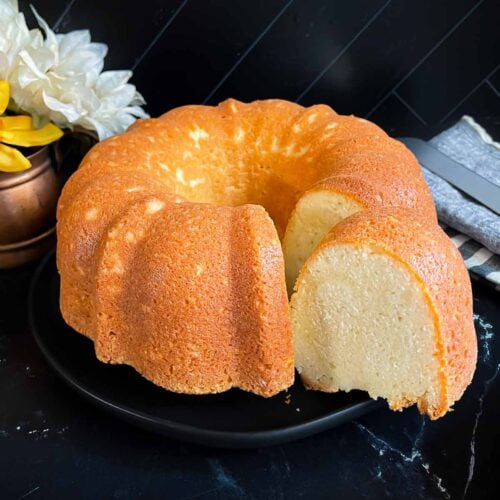 Old fashioned sour cream pound cake on a dark plate.