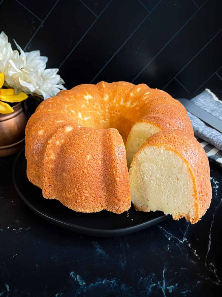 Old fashioned sour cream pound cake on a dark plate.