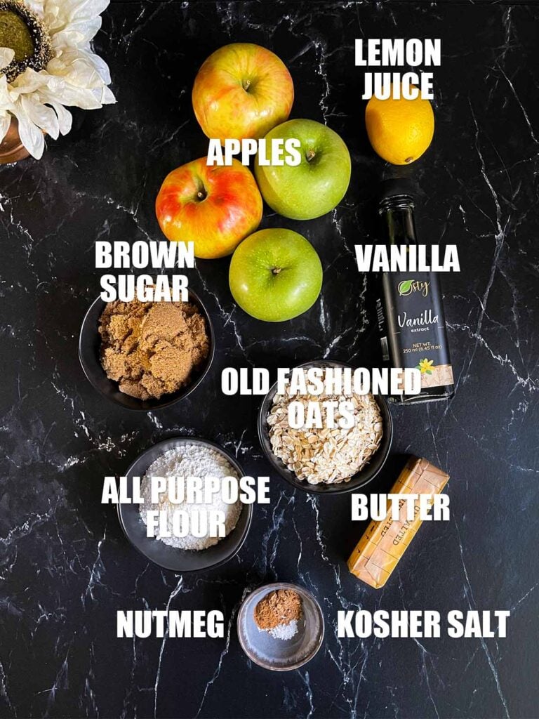 Classic apple crisp recipe ingredients on a dark surface.