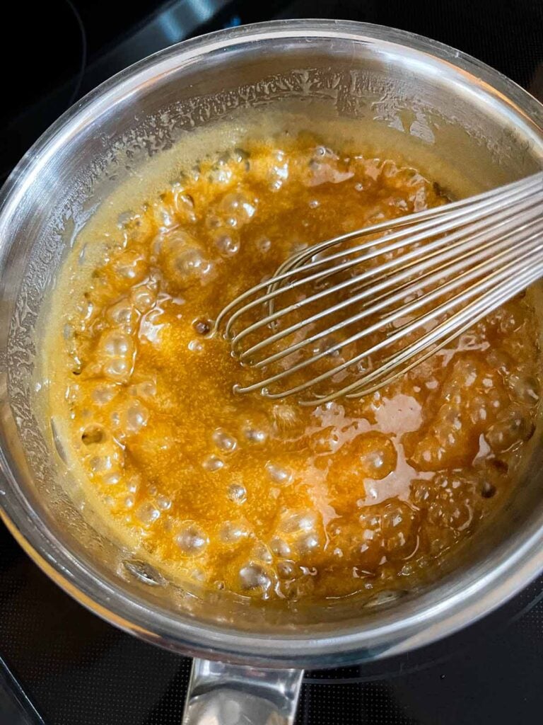Caramel glaze for apple bundt cake boiling in a medium saucepan.