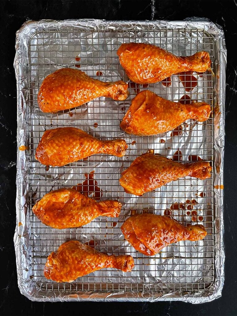 Marinated chicken legs on a cooling rack ready to go onto the smoker.