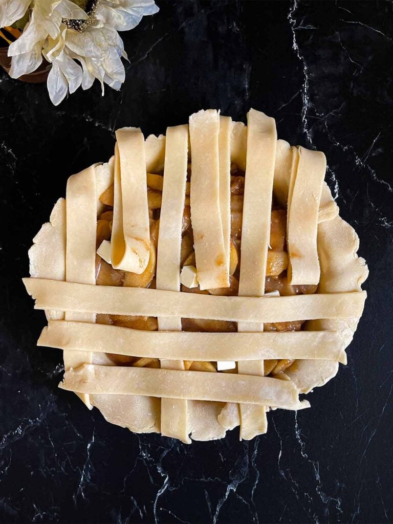 Pie dough strips over the apple pie filling.