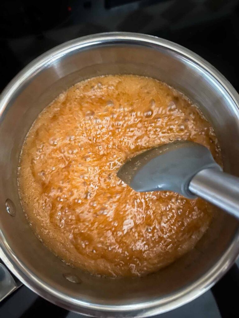 Boiling salted caramel sauce in a saucepan.