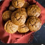 Sweet potato muffins in a cloth lined bread basket on a dark surface.