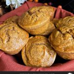 Sweet potato muffins in a cloth lined bread basket on a dark surface.