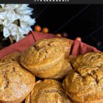 Sweet potato muffins in a cloth lined bread basket on a dark surface.