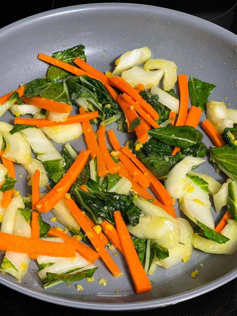 Cooked vegetables for lo mein in a skillet.