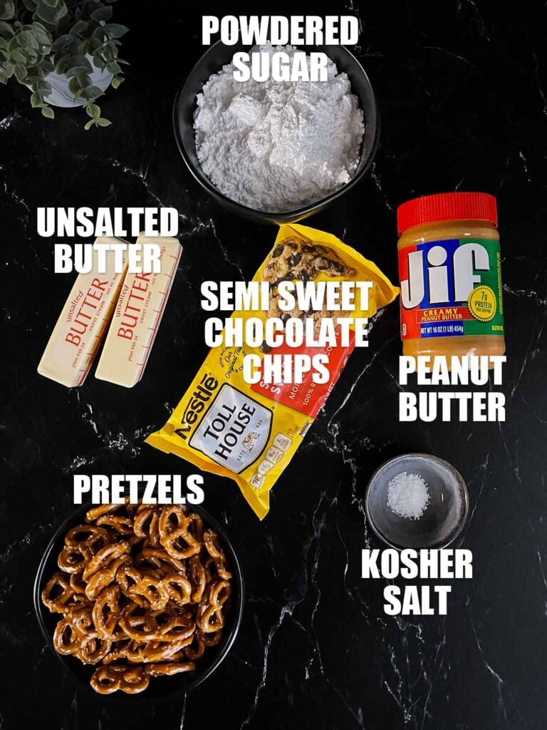 Ingredients needed to make peanut butter pretzel bars on a dark surface.