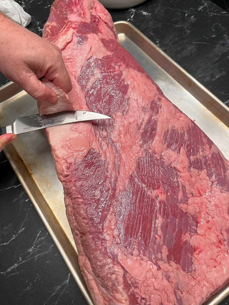 Trimming the deckle out of a brisket.