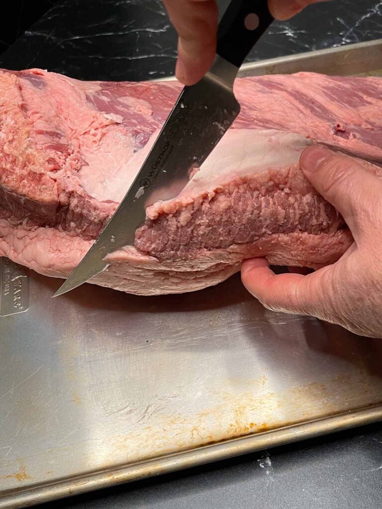 Trimming the edge of a brisket.