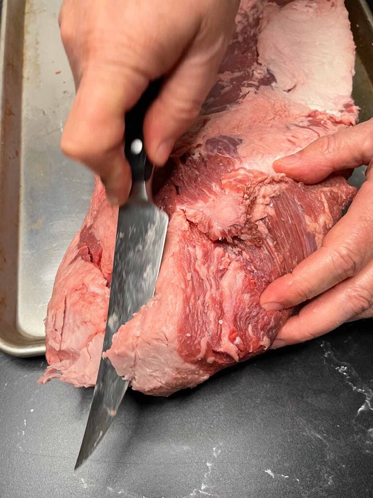 Trimming fat off of a brisket.